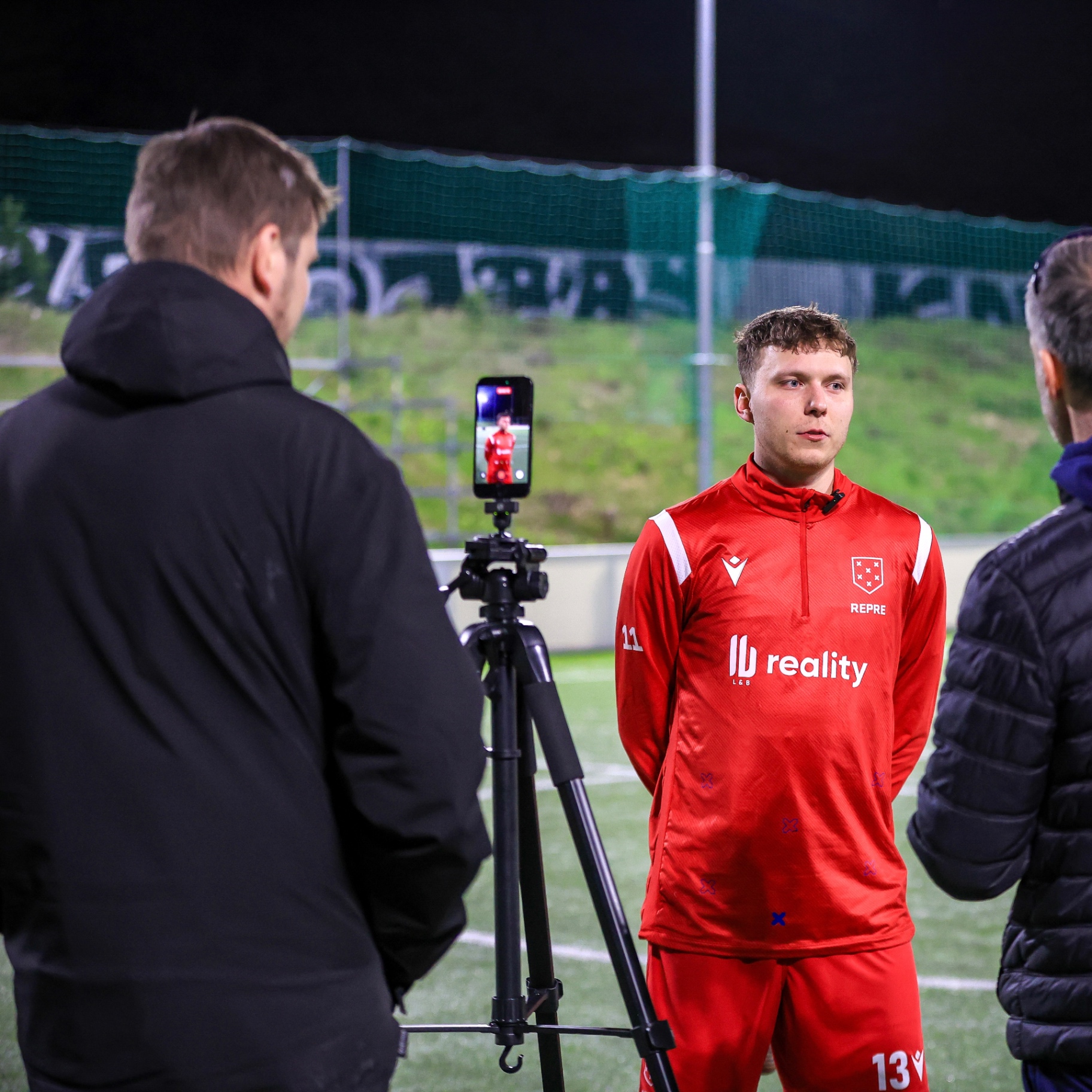 Lukáš Řezníček natáčí kluka v červeném oblečení na fotbalovém hřišti