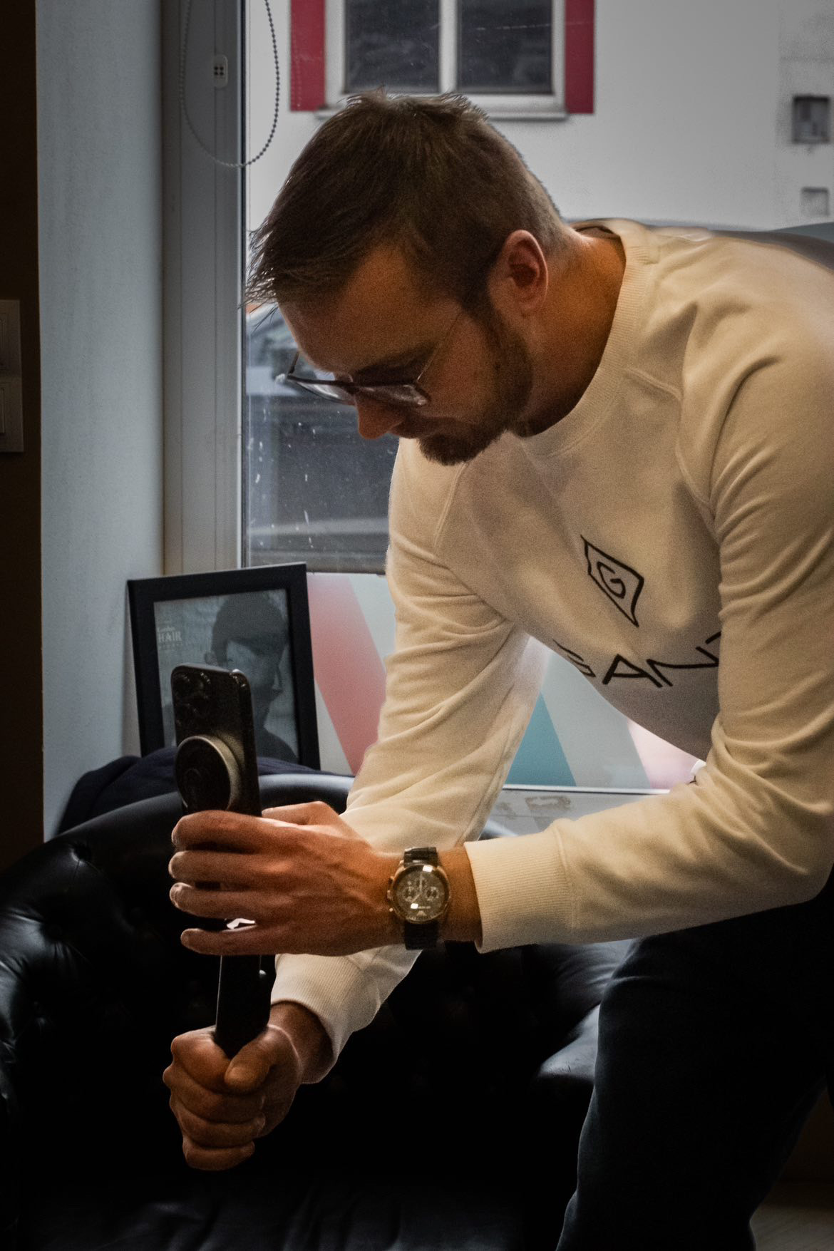 Lukáš Řezníček v pokleku natáčí telefonem na gimbalu